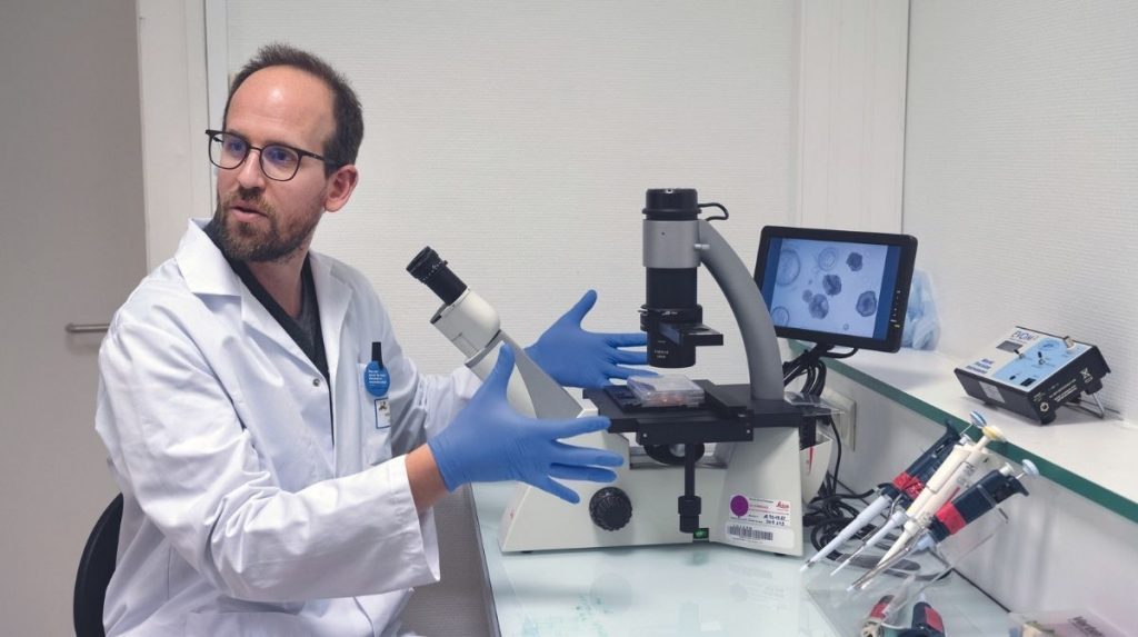 Maxime Mahé devant un microscope.